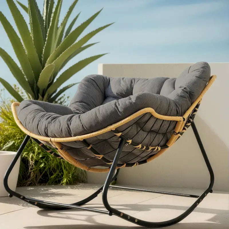 Fauteuil à bascule en rotin tressé gris foncé avec coussins et structure en métal