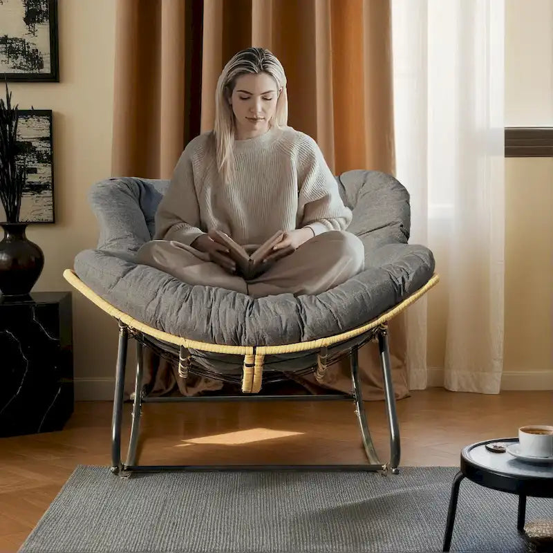 Fauteuil à bascule en rotin tressé gris foncé avec coussins et structure en métal